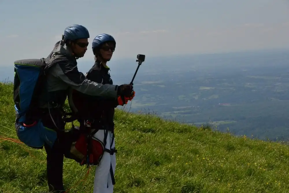 Briefing de sécurité et explications du moniteur aux côtés du passager avant le décollage en parapente
