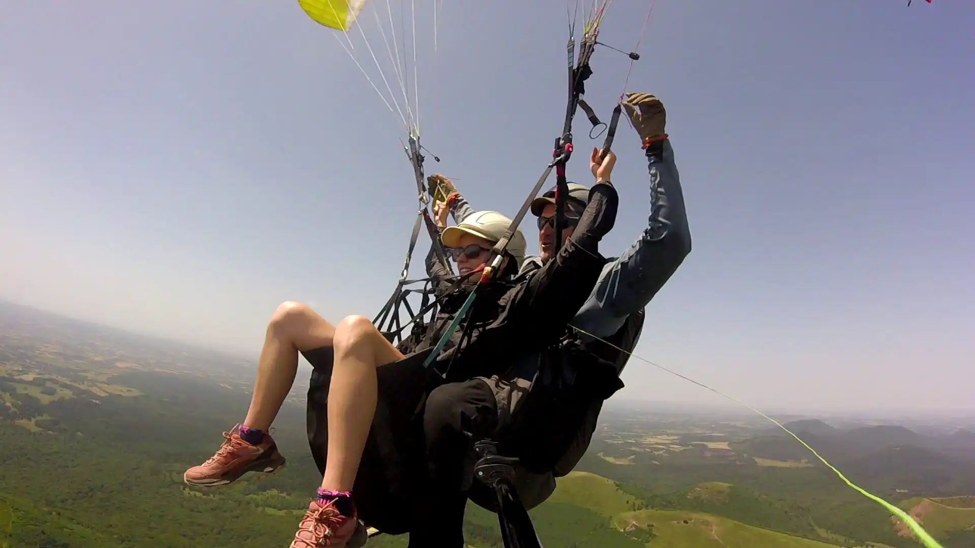Passager s'essayant au pilotage du parapente sous la supervision attentive du moniteur