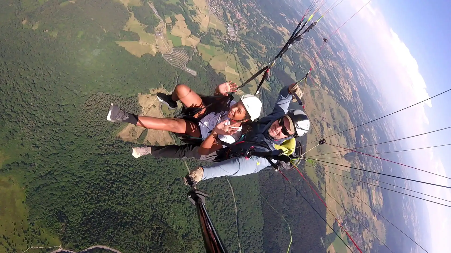 Passager tout sourire profitant pleinement du vol en parapente en haute altitude